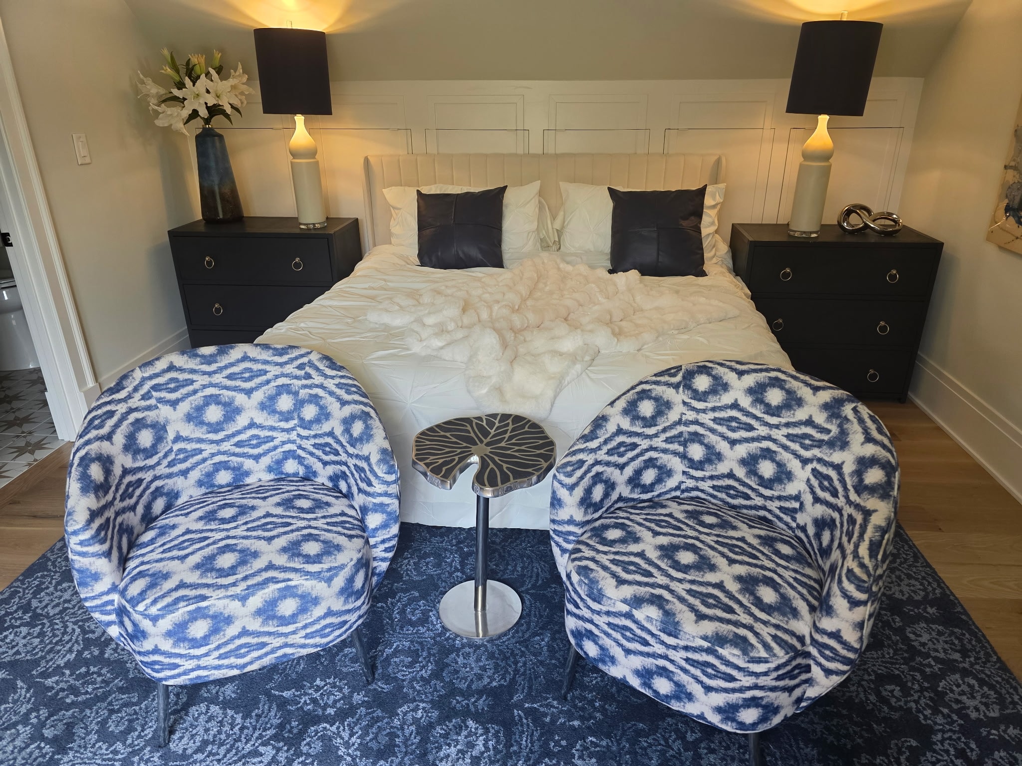 Master bedroom with king bed, blue ikat swivel chairs, and matching nightstands